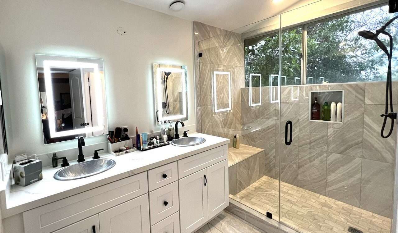 Bathroom with double vanity and glass-enclosed shower