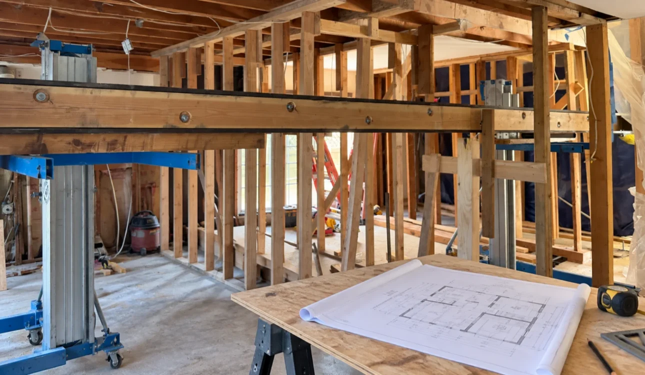 Exposed framing and architectural plans during an Orange County home remodel