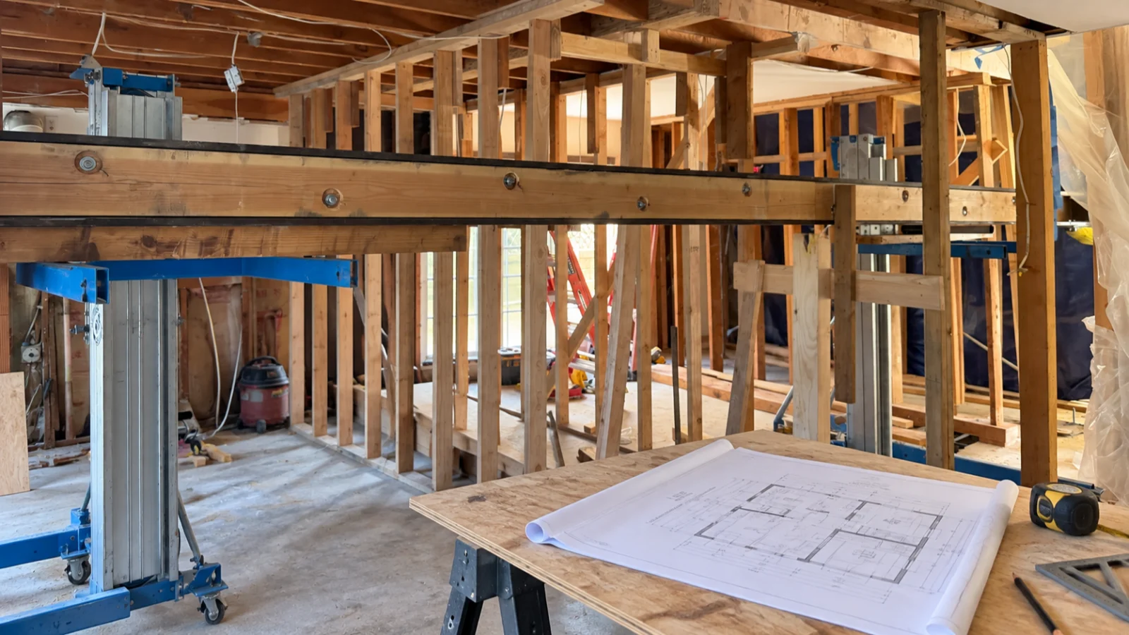 Exposed framing and architectural plans during an Orange County home remodel