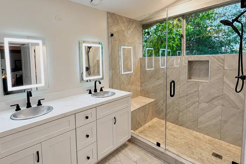 Bathroom with a double vanity, lighted mirrors, skylight and glass enclosed shower